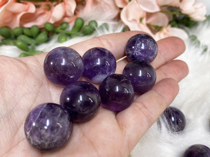 Mini amethyst crystal spheres in hand